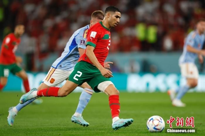 当地时间12月6日，2022卡塔尔世界杯1/8决赛继续进行，摩洛哥队与西班牙队的比赛在教育城球场打响。本场比赛，两队在常规时间和加时赛均无法取得进球，双方进入点球大战。在点球大战中，摩洛哥队凭借门将布努的神奇发挥，两次扑出西班牙球员的点球射门，帮助摩洛哥队淘汰西班牙队，历史首次闯入世界杯8强。图为摩洛哥球员阿什拉夫·哈基米(红)在比赛中。中新社记者 富田 摄